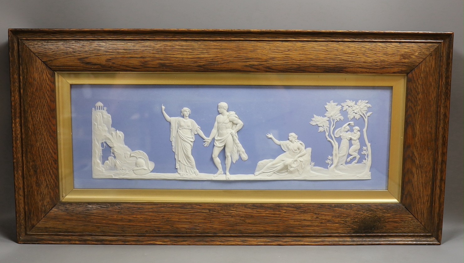 A large Wedgwood blue jasper plaque, early 20th century, impressed mark Wedgwood England, plaque 44 cm X 14 cm, framed and glazed